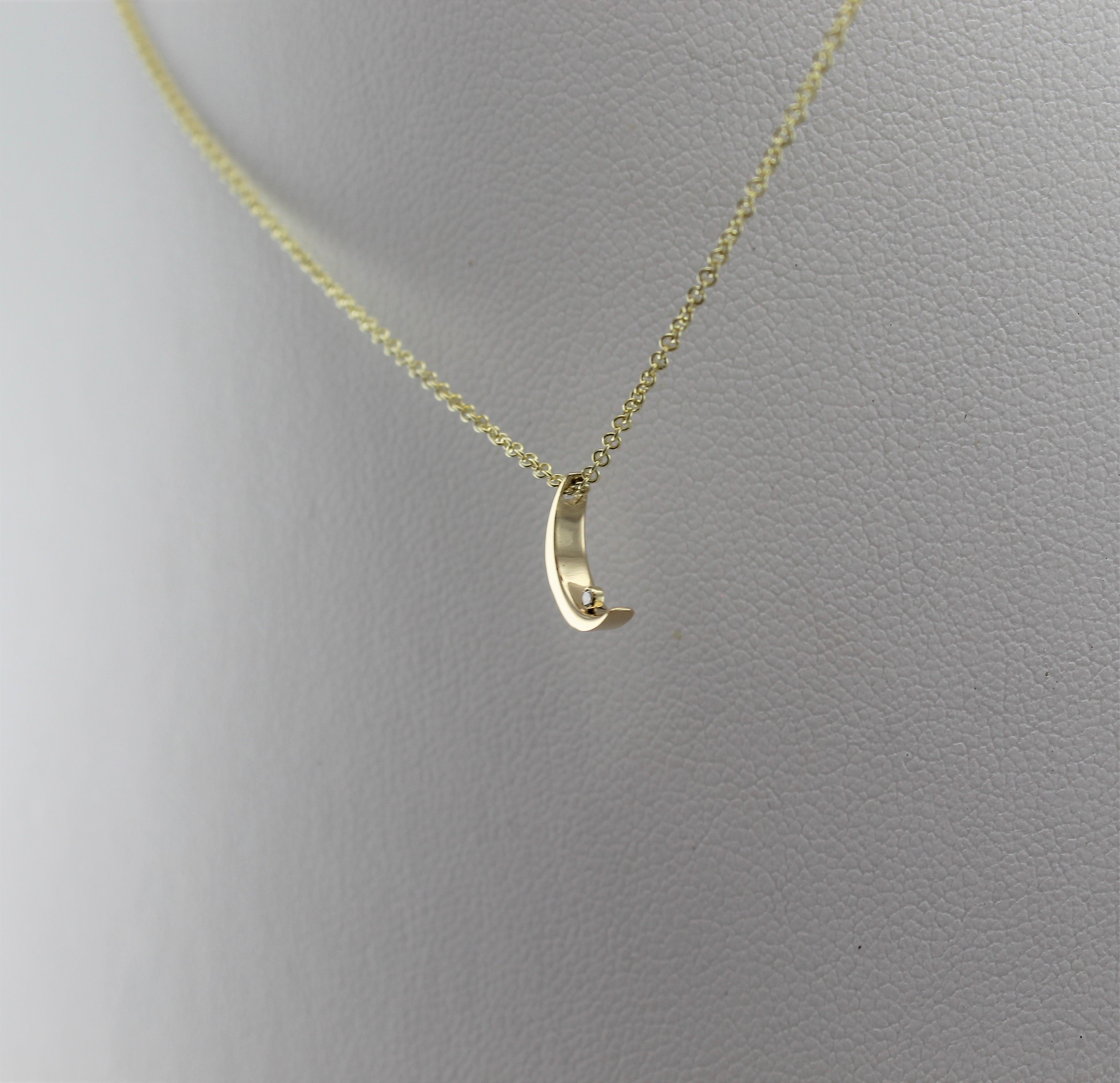 14k Yellow Gold Crescent Moon with Diamond Pendant, low angle view of necklace dangling from mannequin neckline. 