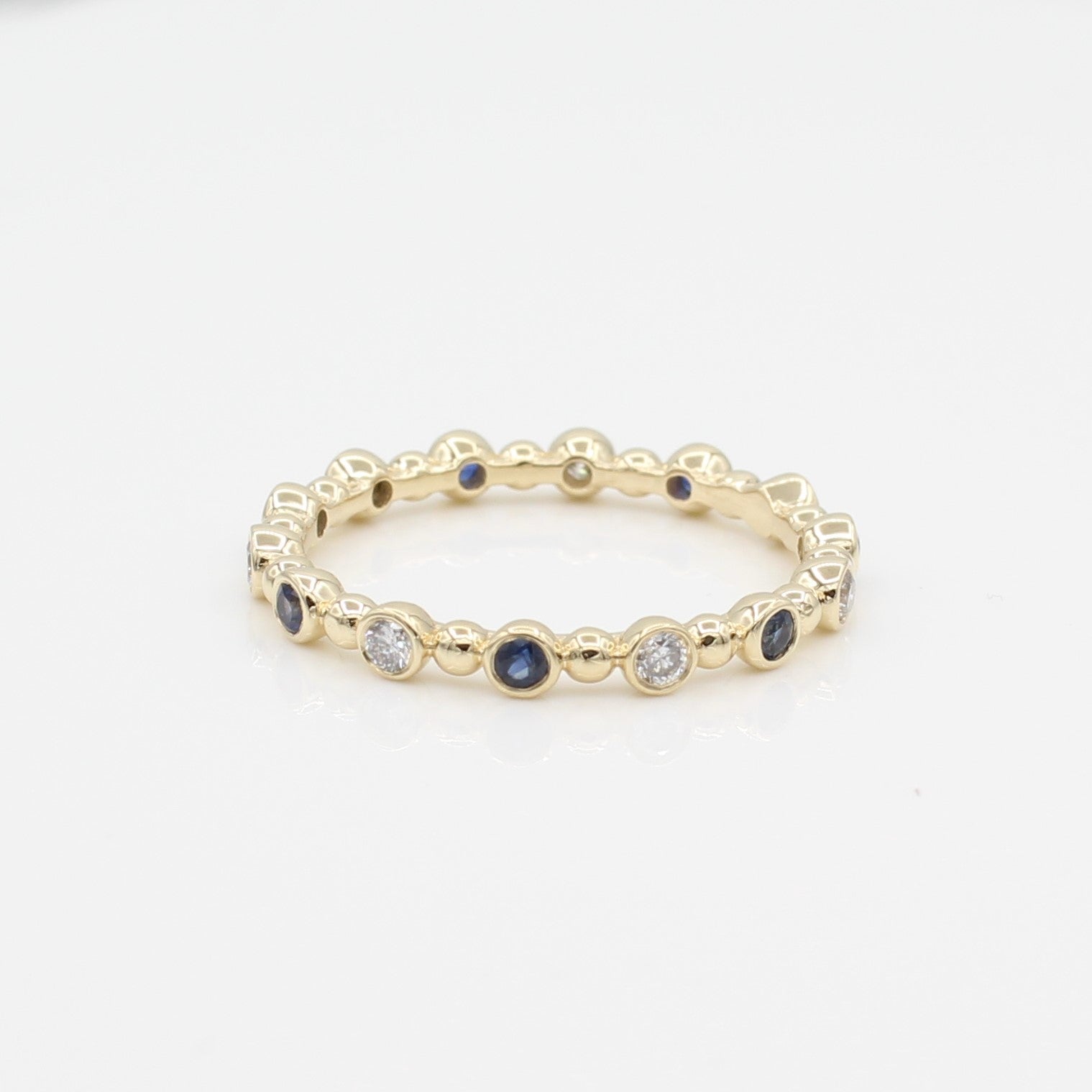 14k Yellow Gold Diamond & Sapphire 14 Station Beaded Eternity Band, front view. 