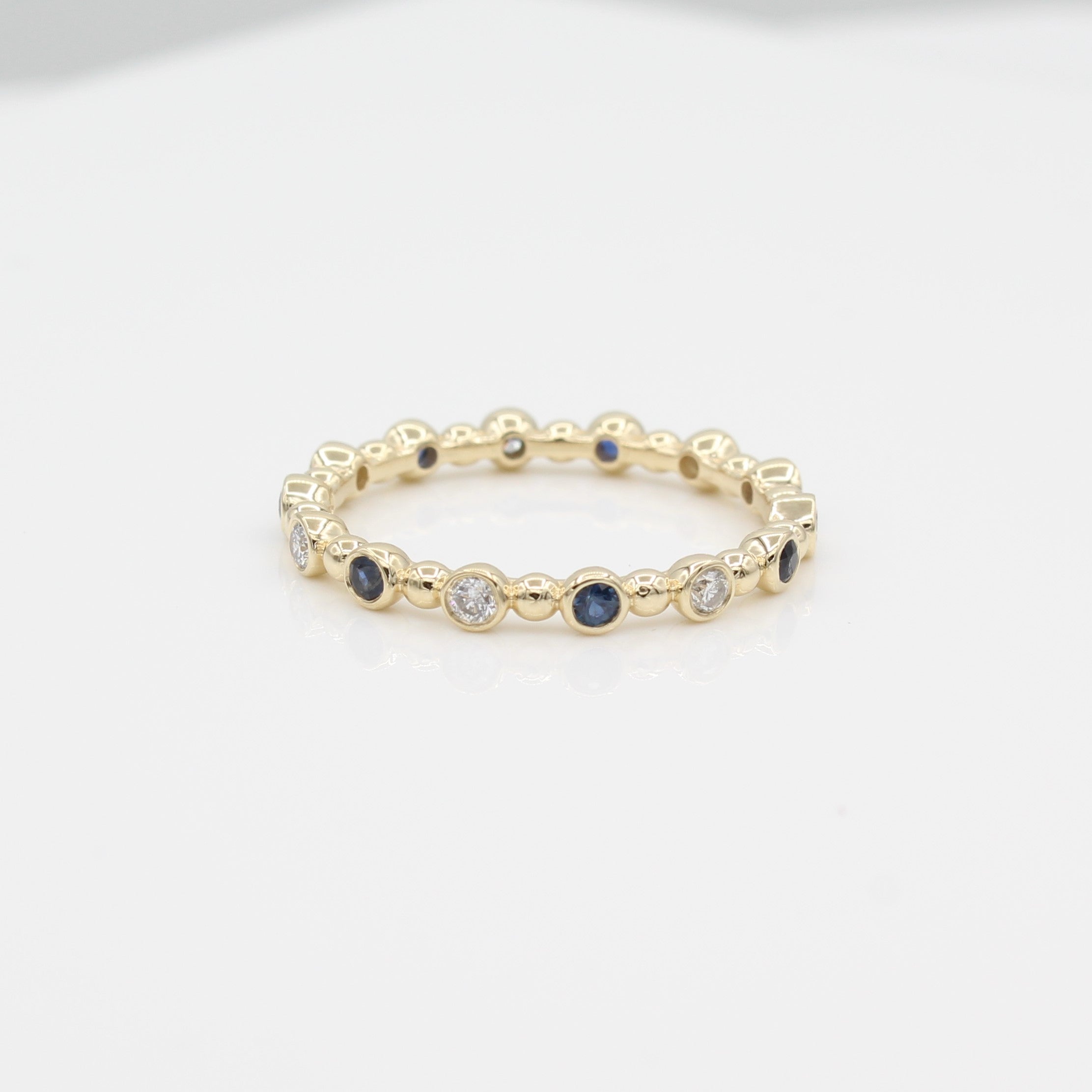 14k Yellow Gold Diamond & Sapphire 14 Station Beaded Eternity Band, front view.