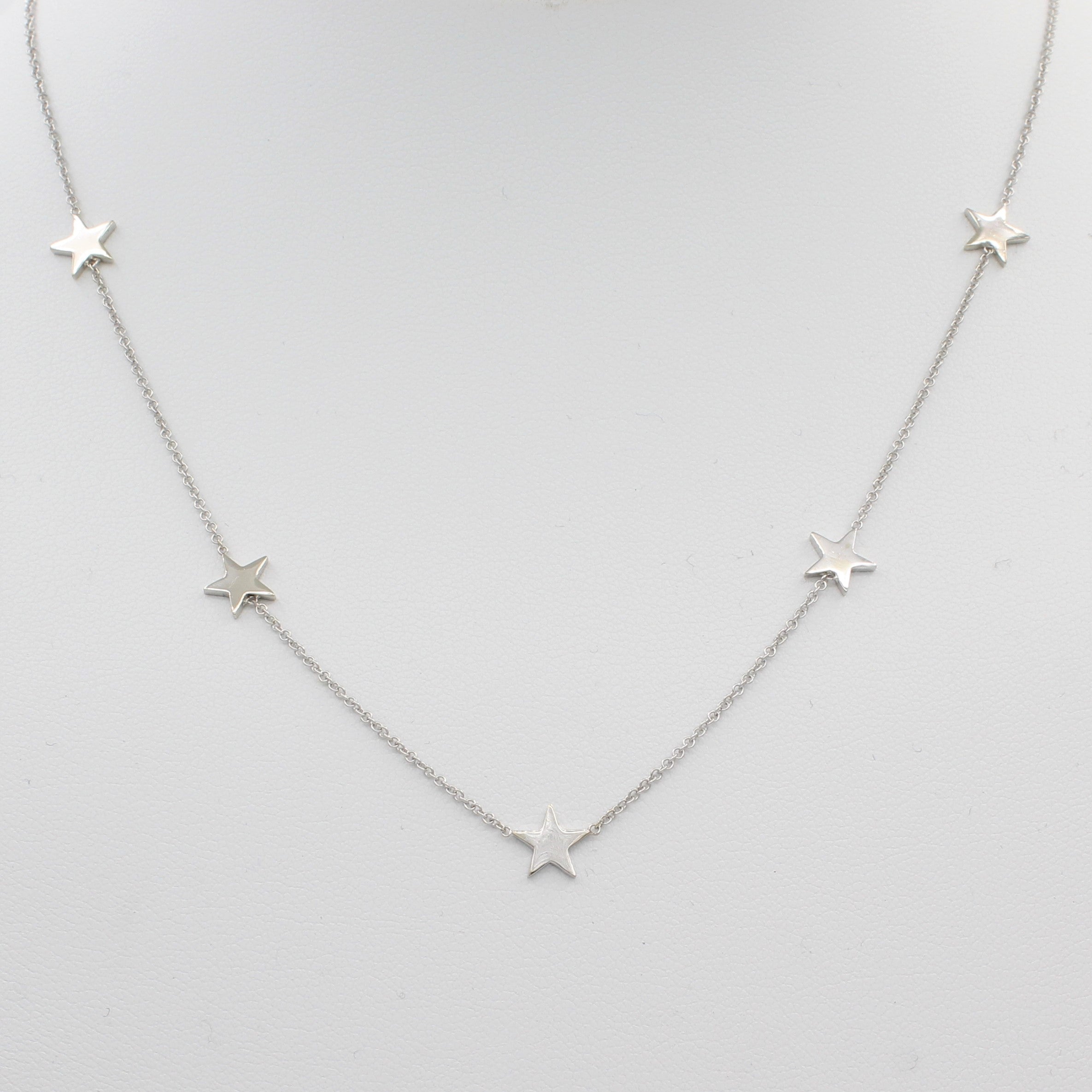 14k White Gold Five Station Star Necklace, front view of necklace displayed on mannequin neckline.