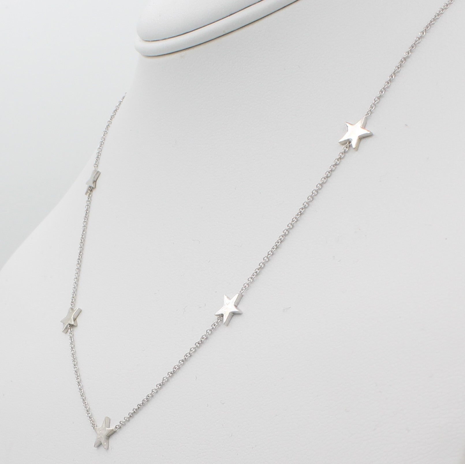 14k White Gold Five Station Star Necklace, right angle view of necklace displayed on mannequin neckline.