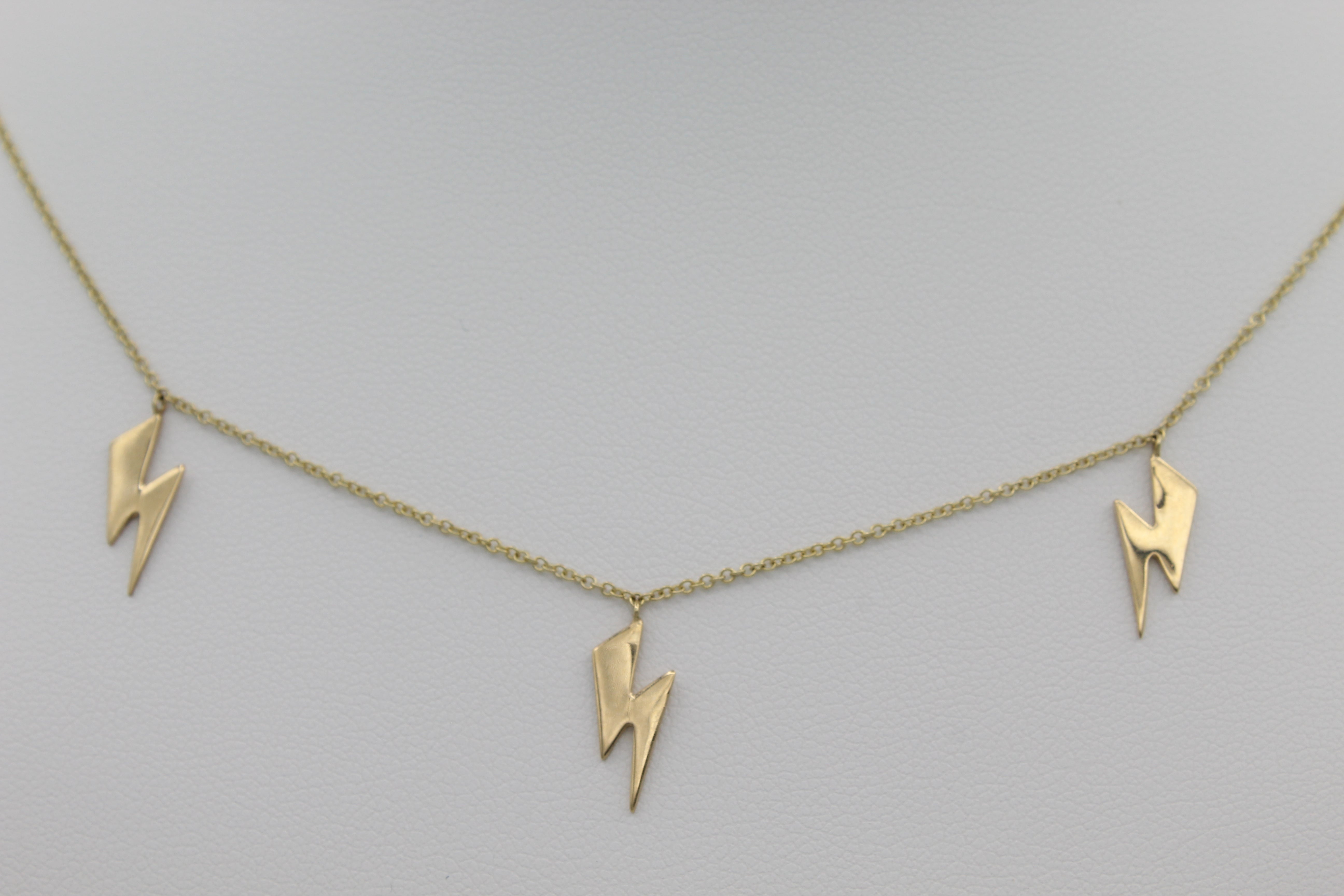 14k Yellow Gold Lightning Bolt Five Station Necklace, close-up front view of three of the necklace's five lightning bolt designs.