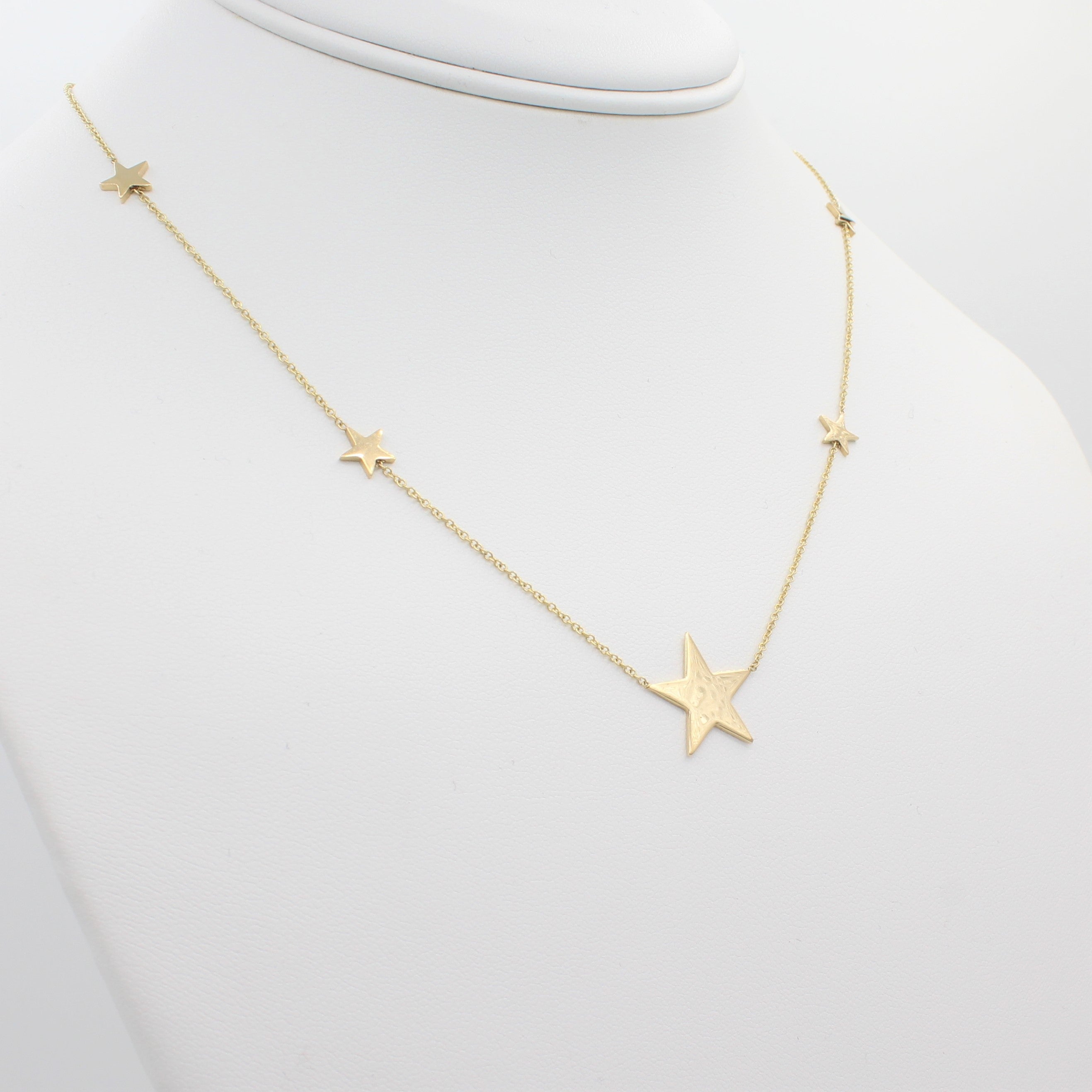 14k Yellow Gold North Star Five Station Necklace, front view of necklace displaced on a mannequin neckline. 
