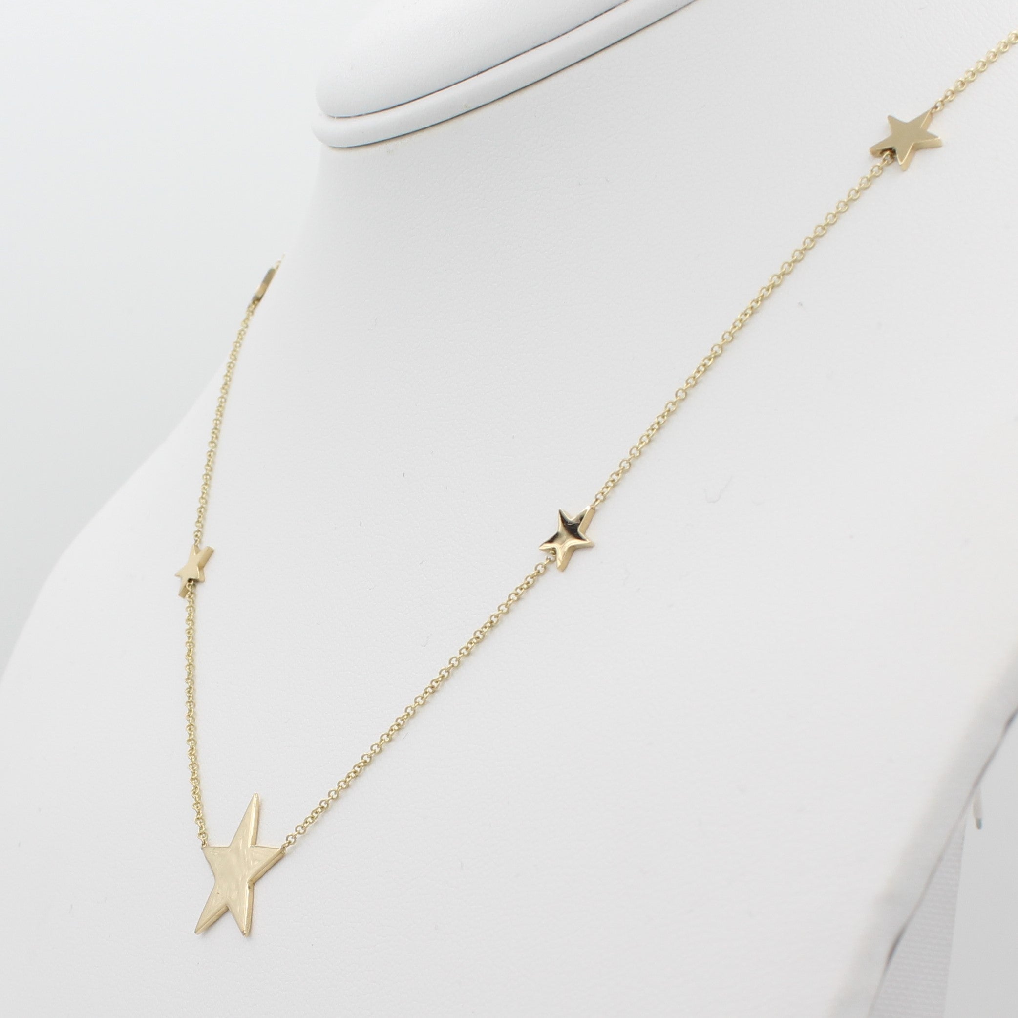 14k Yellow Gold North Star Five Station Necklace, right angle view of necklace displaced on a mannequin neckline. 